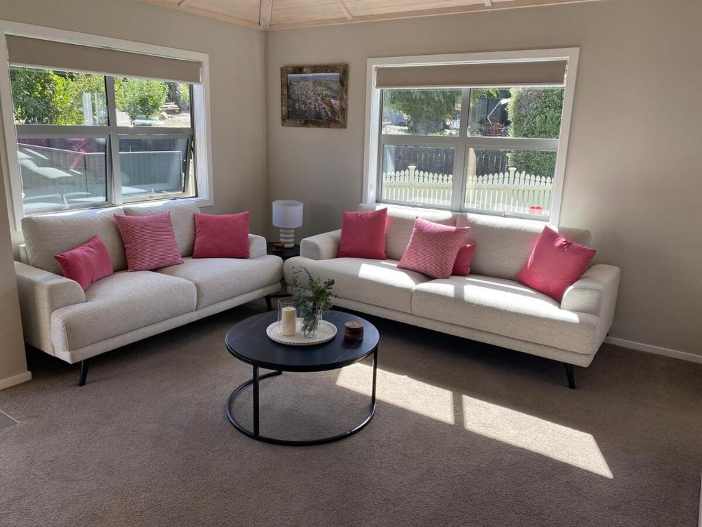 a living room with two couches and a table at Sunny Clyde Getaway in the Heart of Clyde in Clyde