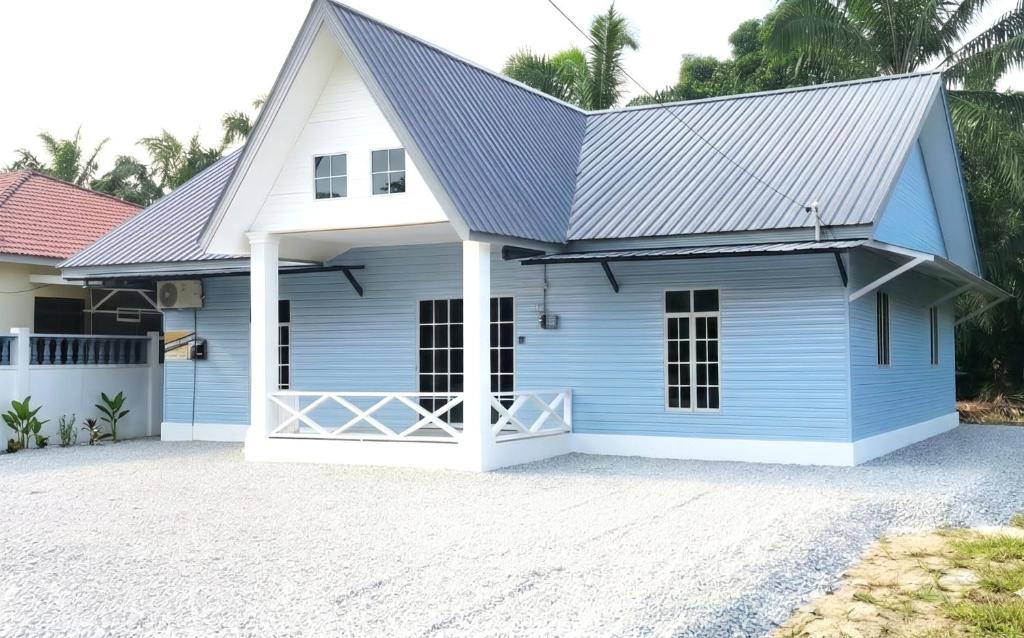 a blue house with a metal roof at Amyza Homestay 3Bilik in Semerah