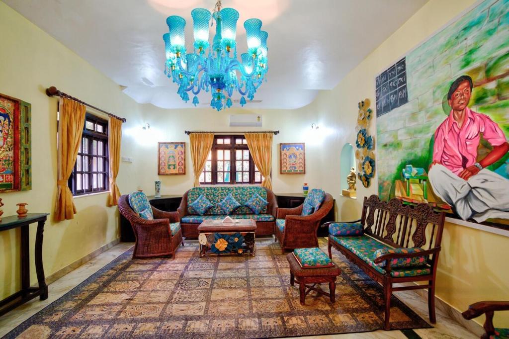 a living room with a chandelier and a couch and chairs at Baagh House villa Velsao in Cansaulim