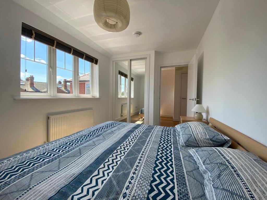a bedroom with a bed with a blue and white comforter at Lovely Central Romsey Apartment in Romsey