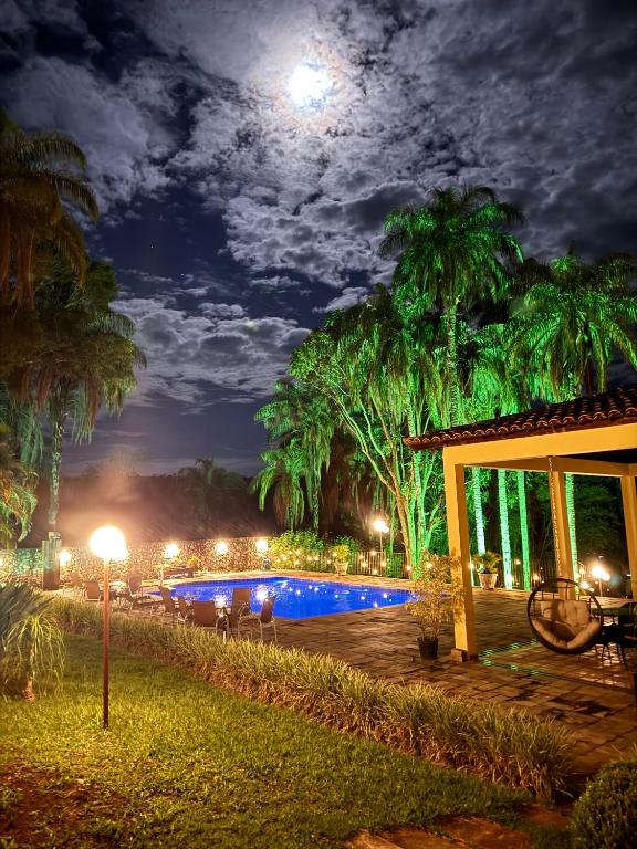 a pool at night with the moon in the sky at Pousada Vila Leopoldina in Tiradentes