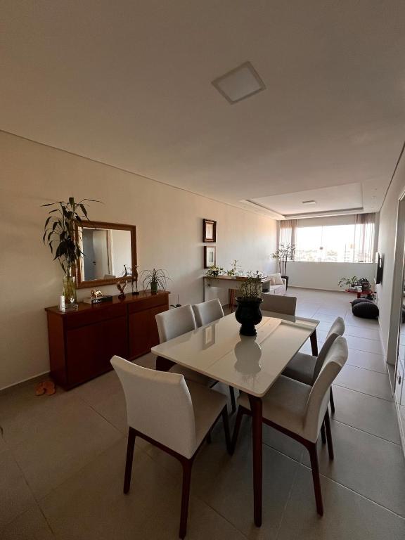 a dining room with a table and chairs and a mirror at Apto Moderno no Centro - Completo e Confortável in Americana