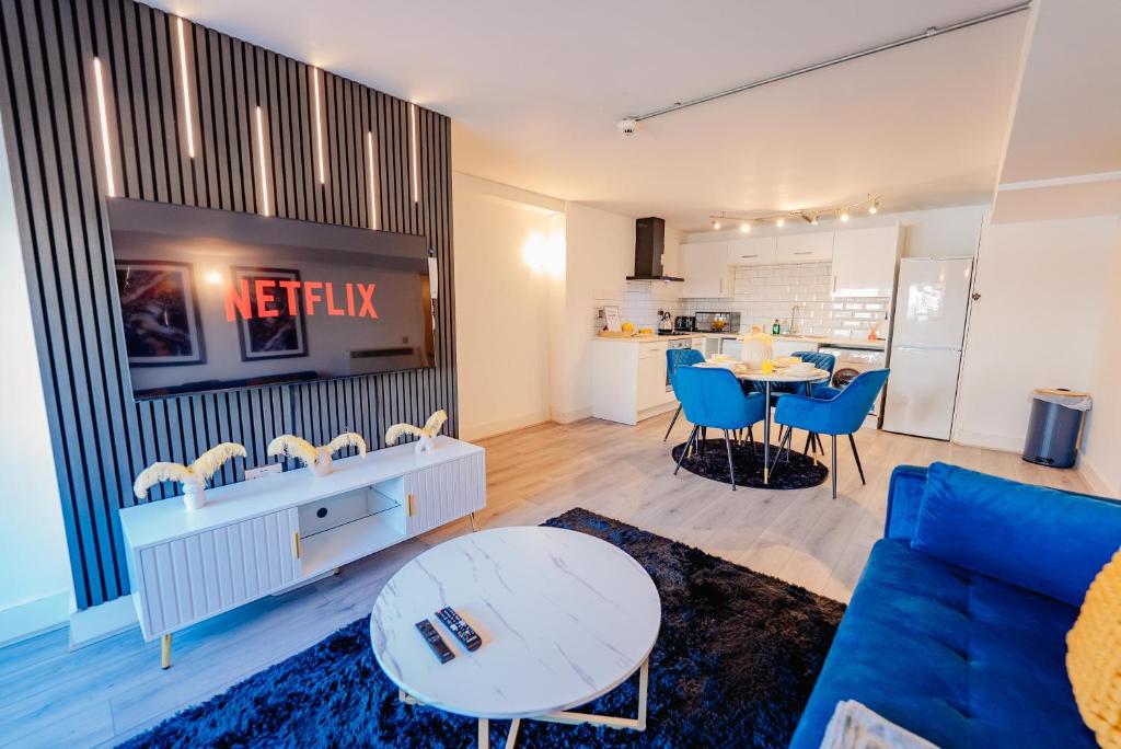 a living room with a blue couch and a table at Modern 2 BR 2 Bath Flat With Balcony & Fast WiFi in Cardiff