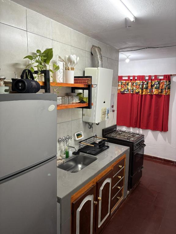 a kitchen with a stove and a sink and a refrigerator at Jerarquizado M Rentals in Santiago del Estero