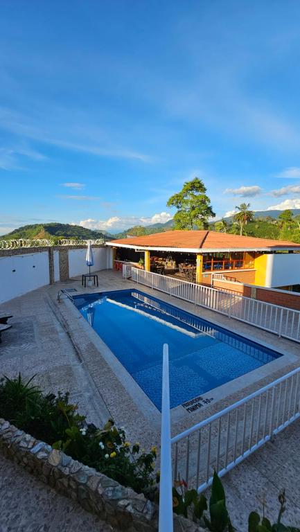 a swimming pool in front of a building at Finca los Bohíos in Santa Rosa de Cabal