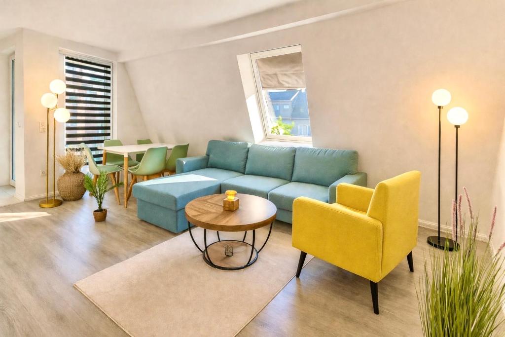 a living room with a blue couch and yellow chairs at Neubau Stadtwohnung mit Balkon in Siegen Parkplatz WLAN Autobahn in Siegen