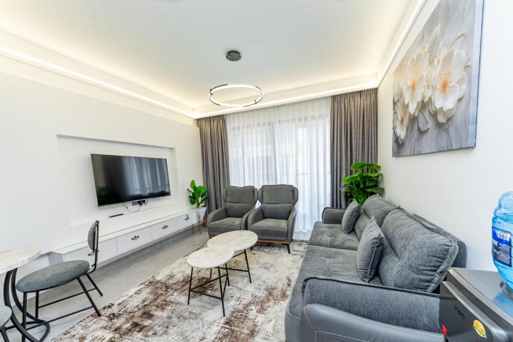 a living room with a couch and a tv at The Residence -Juction Mall in Nairobi
