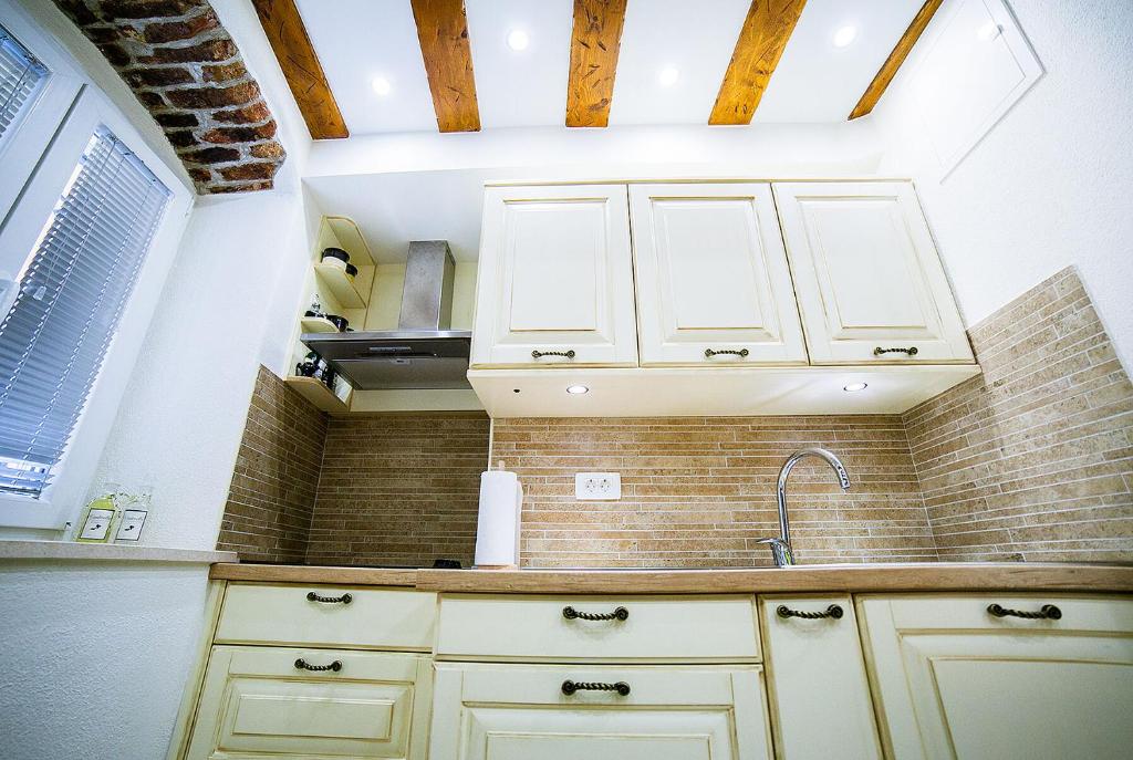a kitchen with white cabinets and a sink at Apartment Genius Loci in Split
