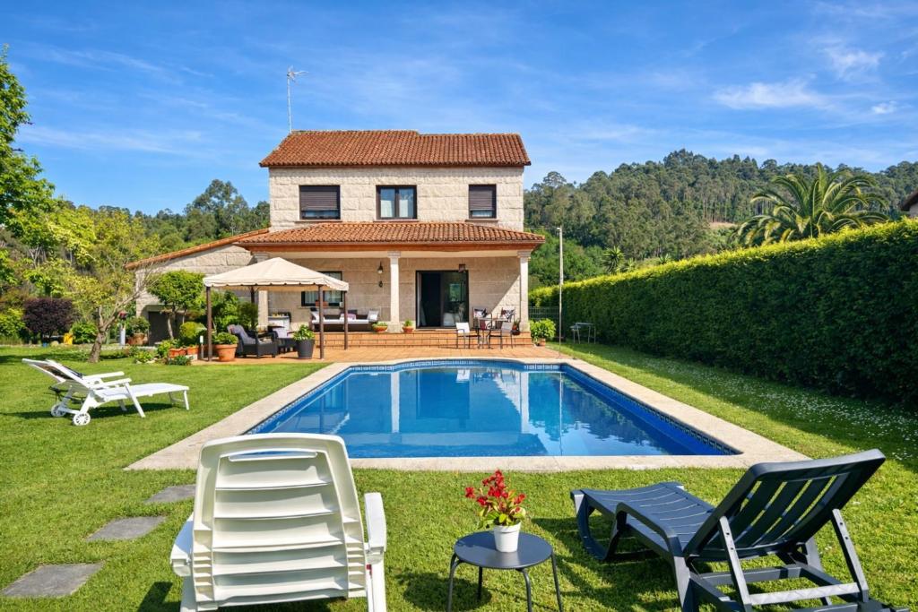 a villa with a swimming pool in front of a house at Holibai, Feiticeira, Vacaciones familiares, Casa de Ensueño en Galicia in Gondomar