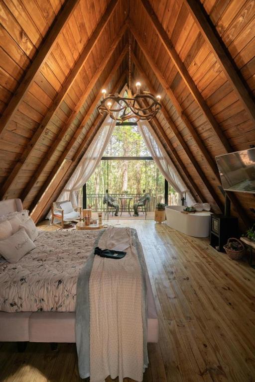 a large bedroom with a bed in a wooden ceiling at Lohma Nature in Gramado