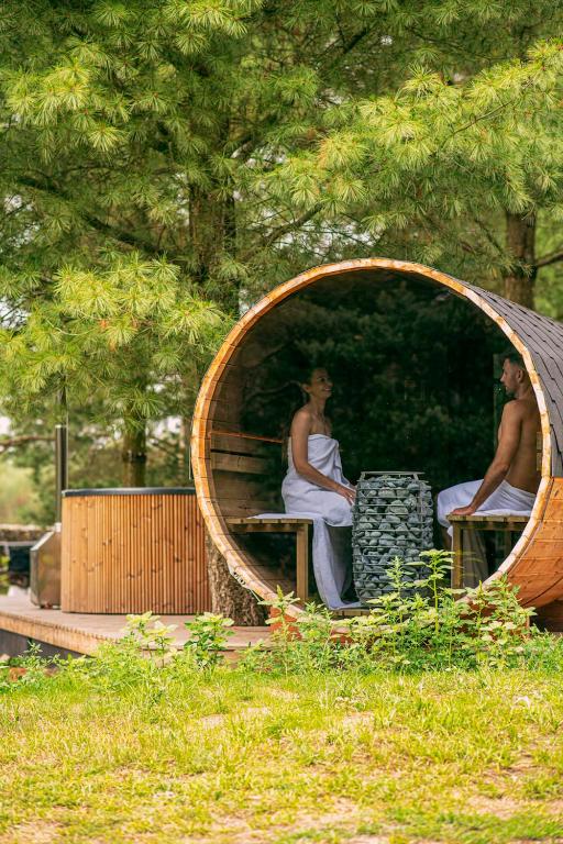 mężczyzna i kobieta siedzący w okrągłym lustrze w obiekcie Bajka Resort & GARDEN SPA w mieście Grodziec