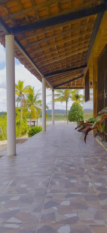 an empty patio with palm trees in the background at Sítio de Vavá in Gravatá
