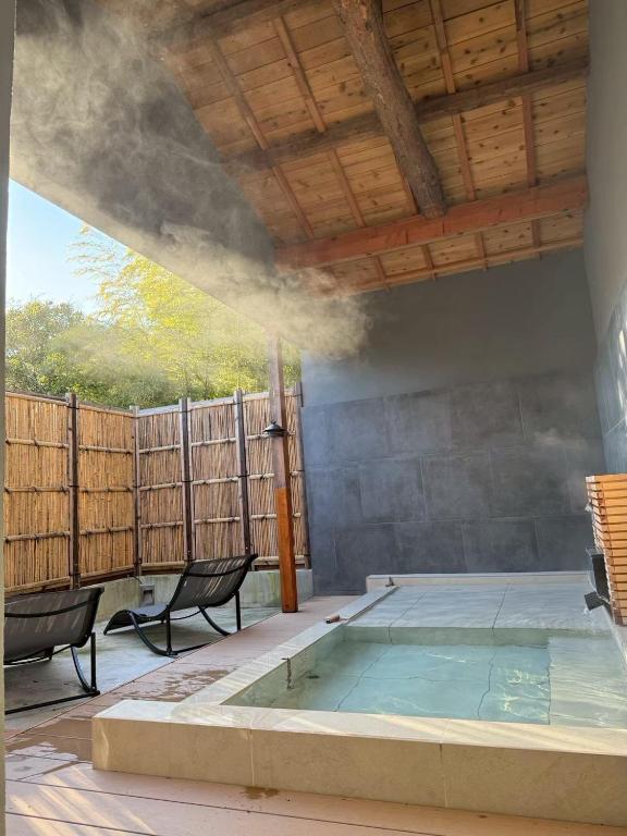 a swimming pool with two chairs and a wooden ceiling at TIMeSCAPE -hakone- in Miyanoshita