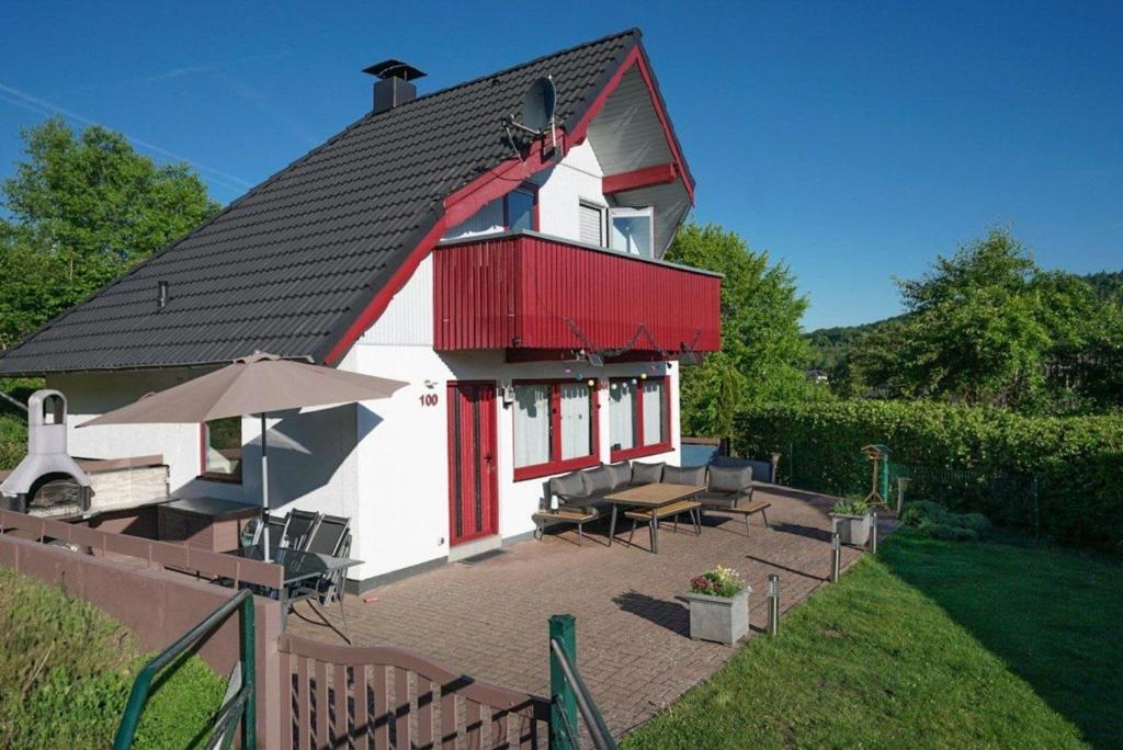 a red and white house with a patio at BärenNest Haus in Kirchheim