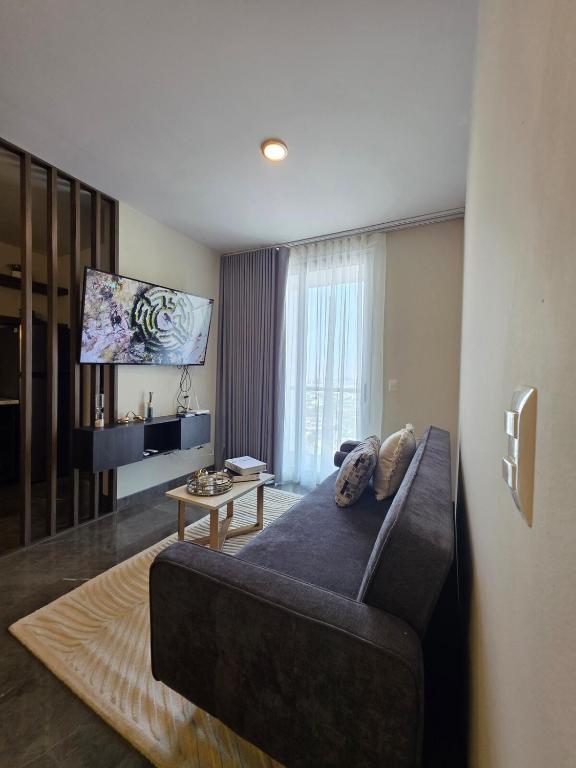 a living room with a couch and a flat screen tv at Puntacero Fundidora 1604 Cintermex in Monterrey