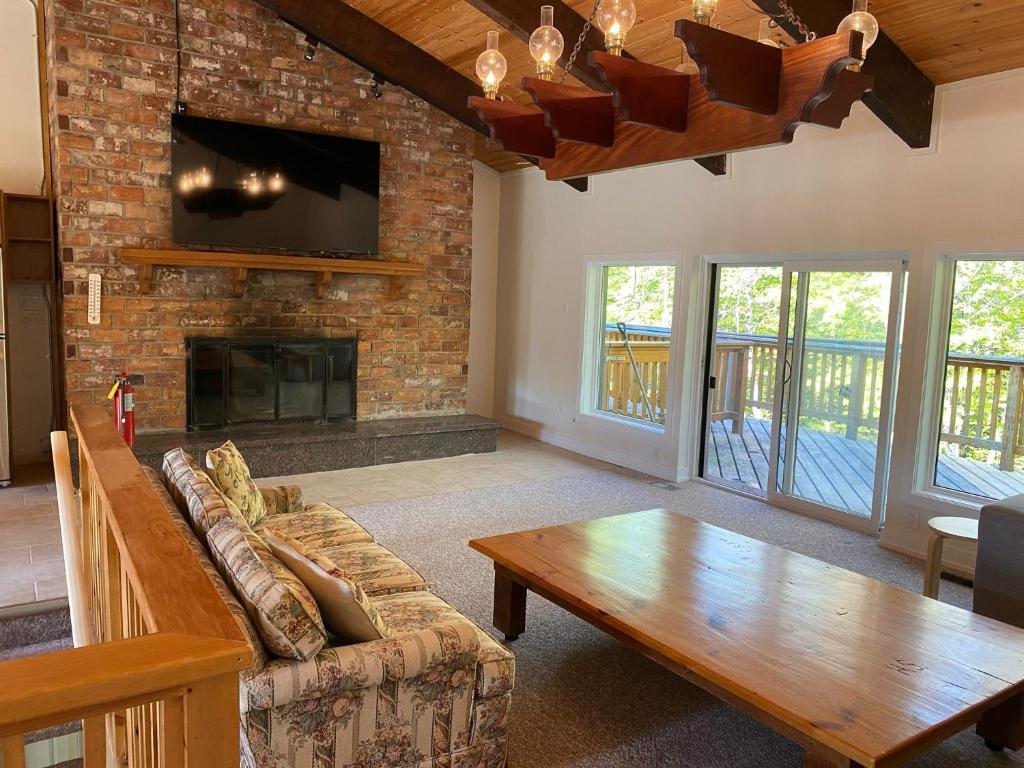 a living room with a couch and a fireplace at Blue Mountain Chalet in Blue Mountains