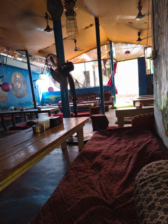 a room with a wooden bench and tables in it at Cookiewalla in Arambol