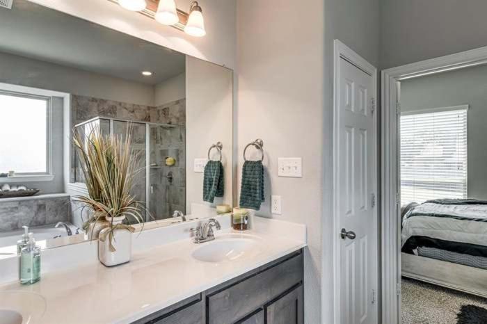 a bathroom with a sink and a mirror and a bed at Dei Puer in Glenn Heights