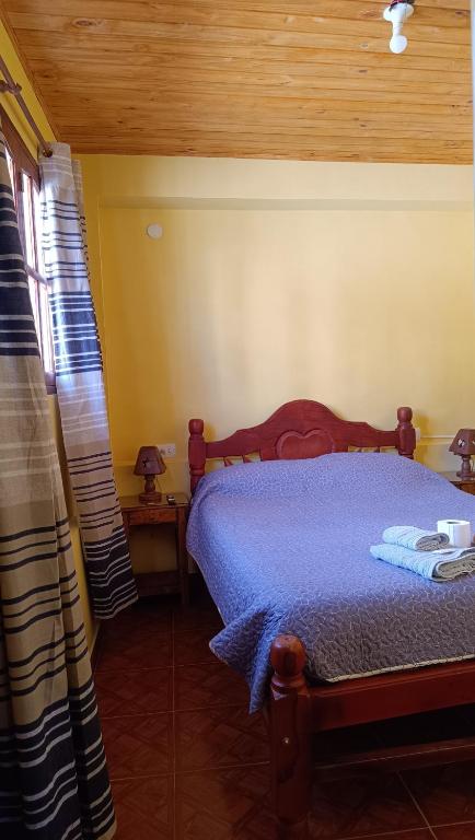 a bedroom with a bed with a blue comforter at El MasSi in Tilcara