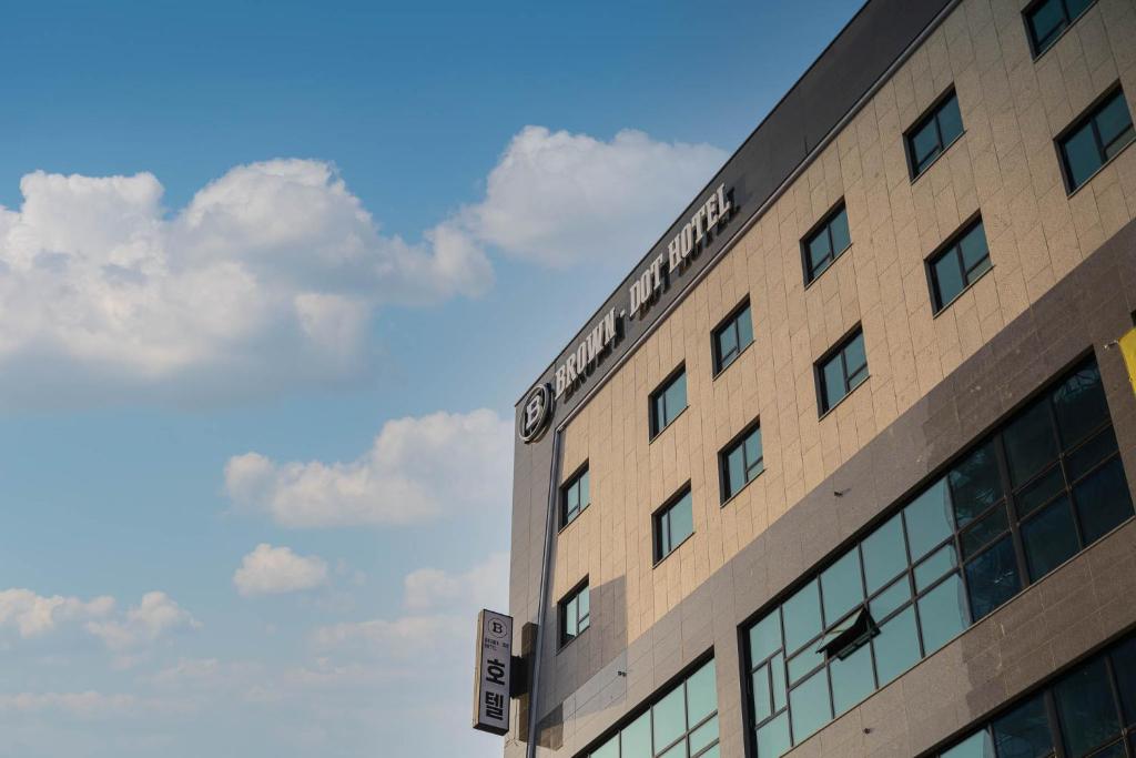 a building with a sign on the side of it at Browndot Hotel Godeok newtown in Pyeongtaek