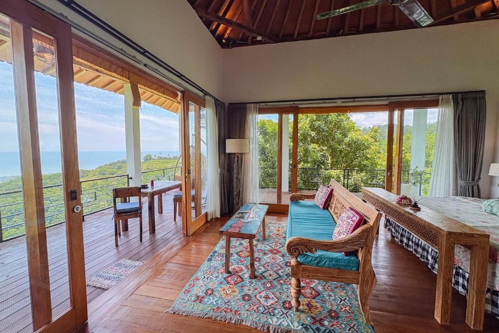 a room with a bed and a balcony with sliding glass doors at LiRi Villa - Ocean, hills, valley view in Lovina