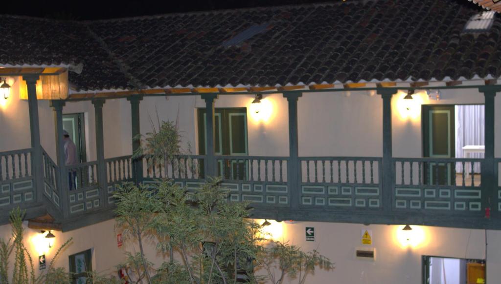 a man standing on a balcony of a house at Qinty Nature Ecolodge in Cusco