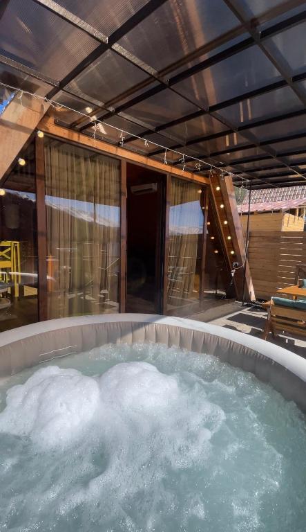 a jacuzzi tub with green water in it at Yerankyun Boutique Cabin in Lermontovo