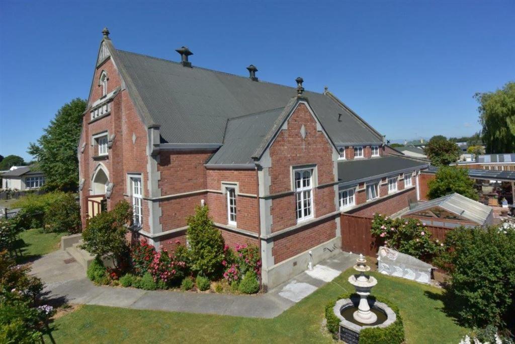 a large brick building with a clock on the front of it at Hall on the Terrace in Temuka