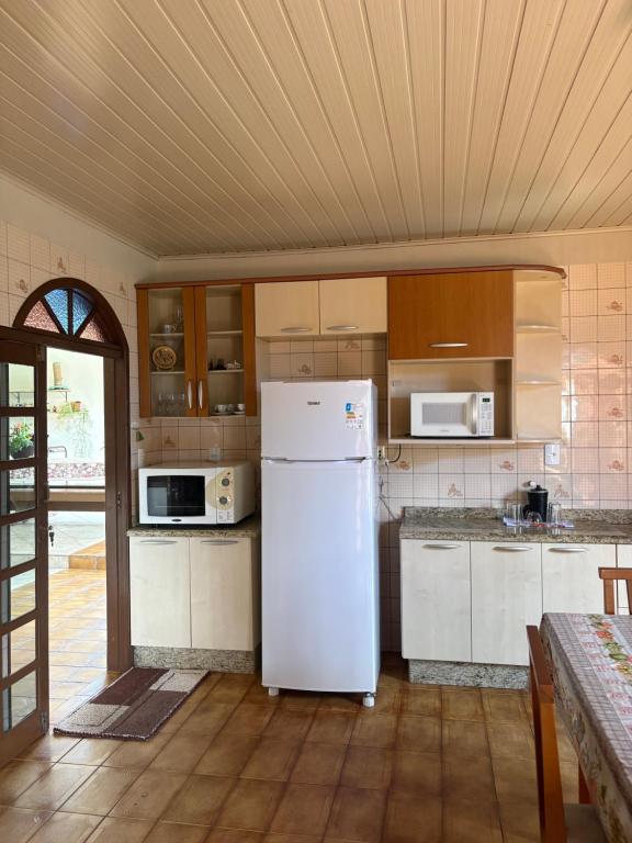 a kitchen with a white refrigerator in a room at Espaço vovô Wilson in Joinville