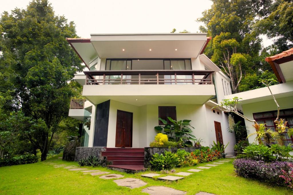 a house with a balcony and a yard at Wikubu Villa in Munduk