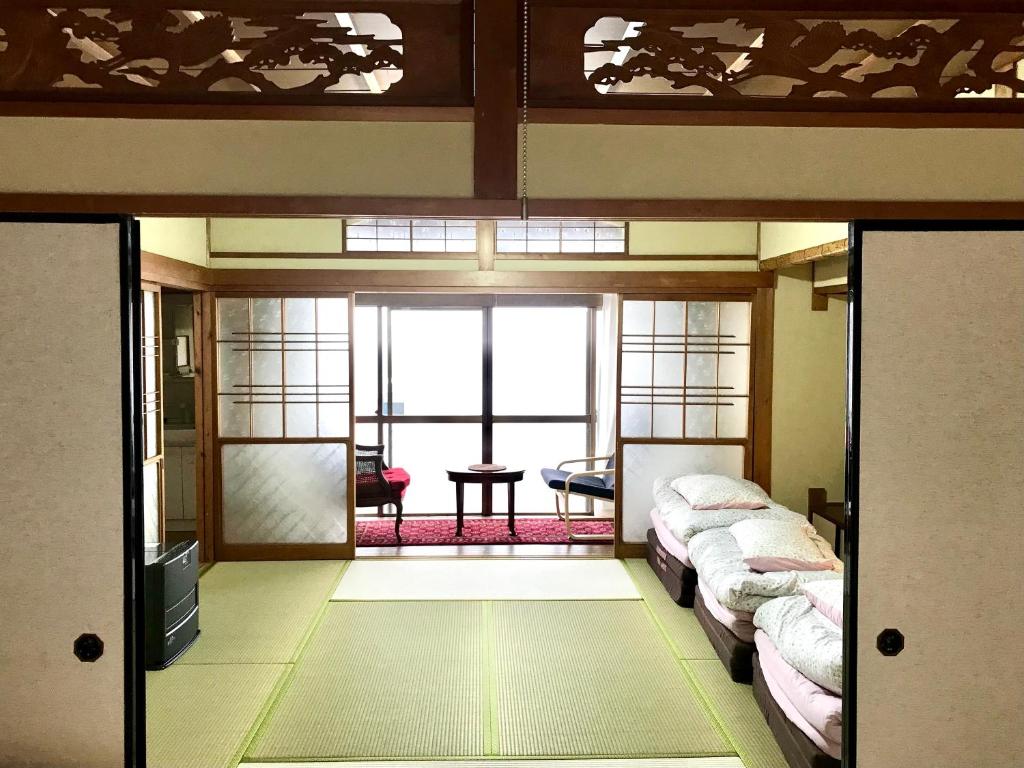 a room with two beds and a table in it at Tora House in Nagoya