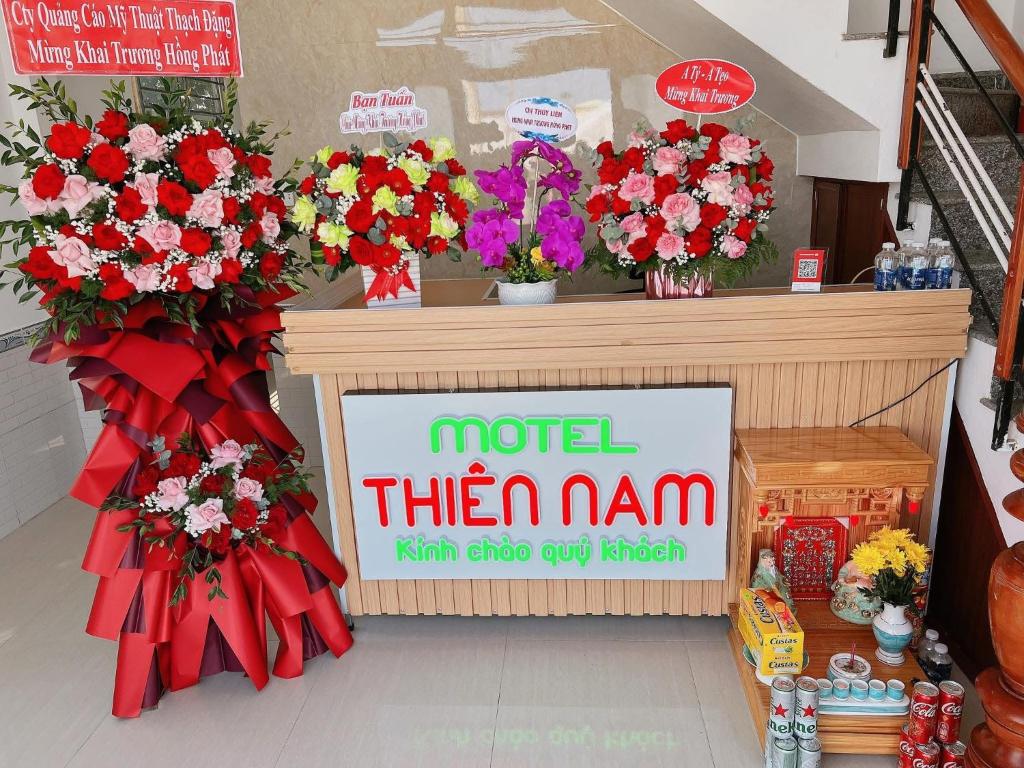 a sign in a store with flowers on a counter at Thiên Nam Motel in Dien Ban