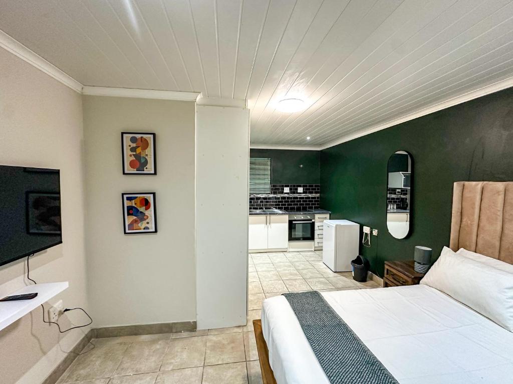 a bedroom with a white bed and a green wall at Silwood Heights Flatlet in Eerste River in Faure