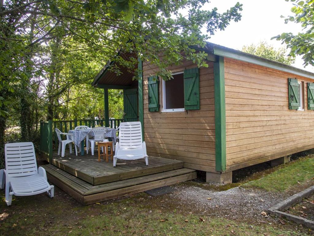 a cabin with chairs and tables on a deck at Chalet avec terrasse - 4 pers. - API-1-52-2108 in Naucelle