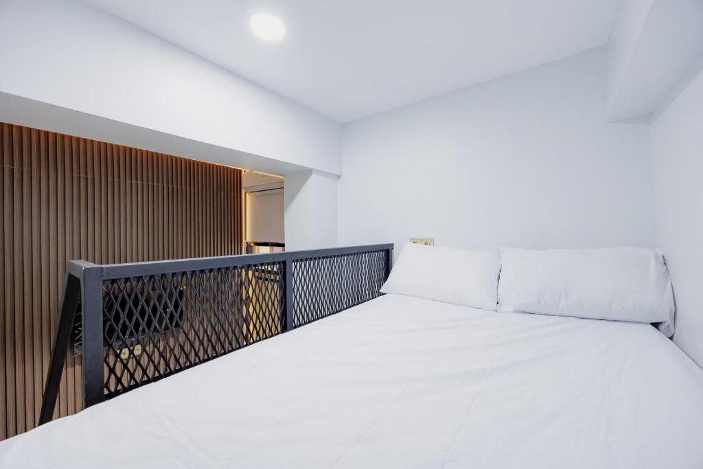 a bed on a balcony in a room at Laurel Inn Menteng in Jakarta