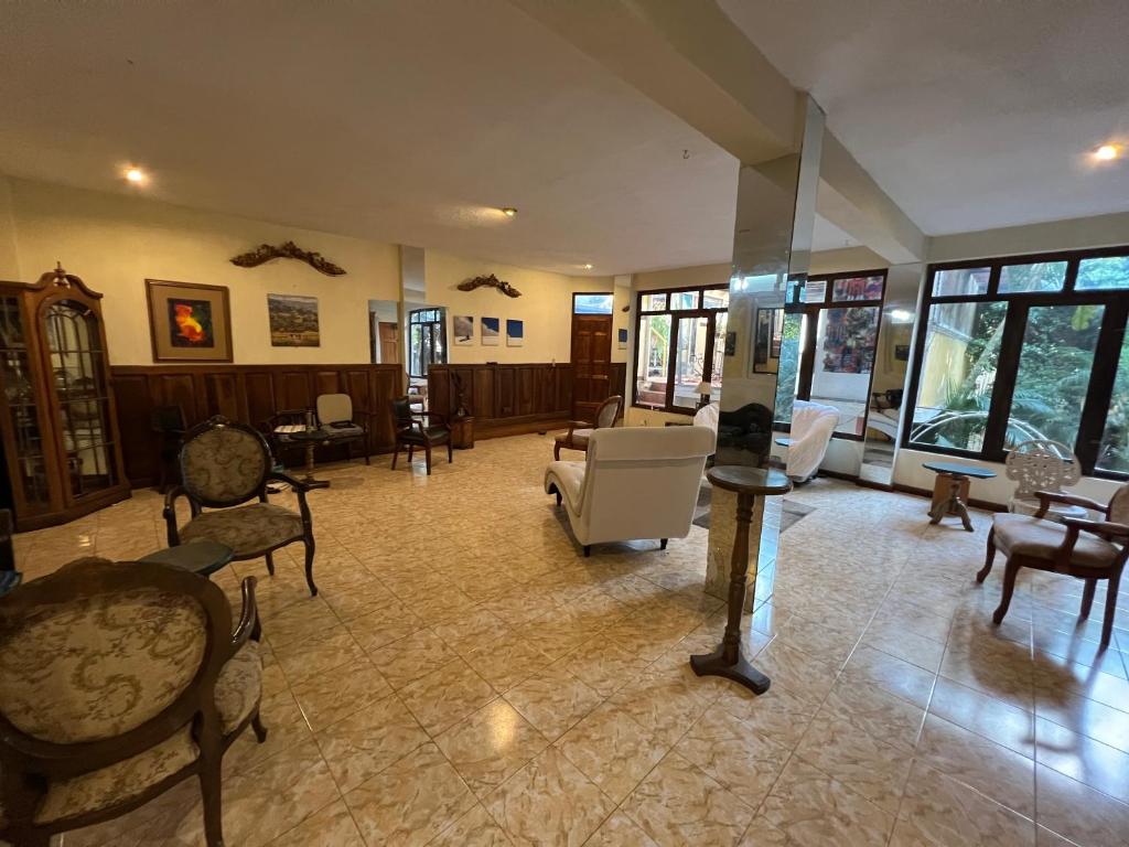 a large living room with chairs and tables at Mansión Del Arco in San Pedro La Laguna