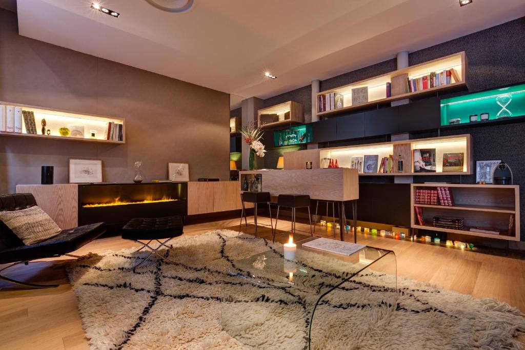 a living room with a fireplace and a table at Hôtel Elixir in Paris