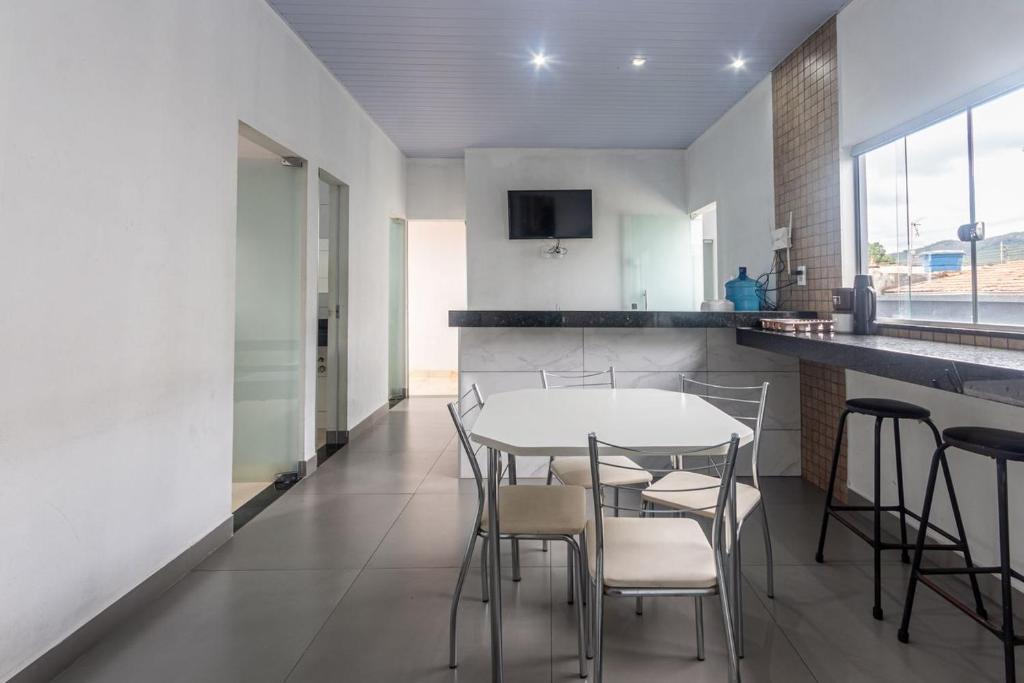 a kitchen with a table and chairs in a room at Apartamento para 6 com Vaga e Churrasqueira in Pará de Minas