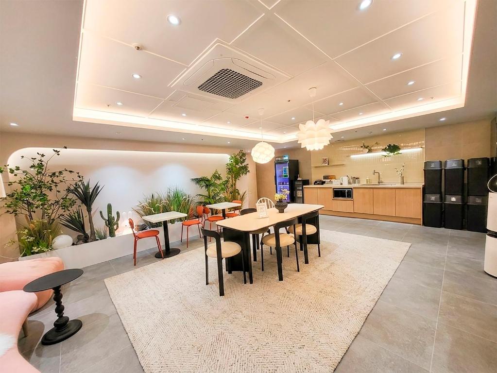a dining room with a table and chairs and a kitchen at 4rest Stay Jongno in Seoul