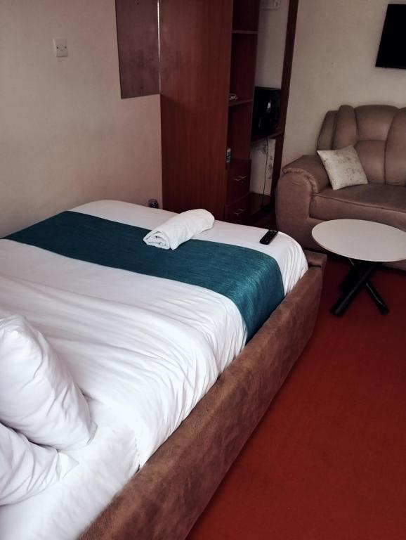 a bed in a room with a couch and a table at Jipso homes in Eldoret