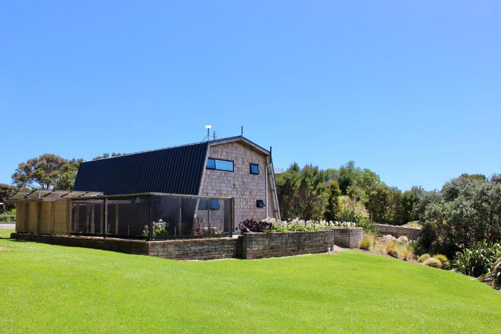 a house on a hill with a green lawn at Whangaroa Barn in Whangaroa