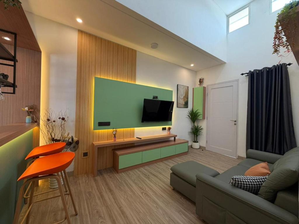 a living room with a couch and a flat screen tv at Pendo Mansion in Pulau Sembakau Kecil