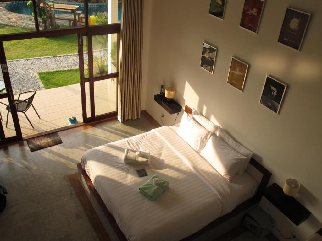 a bedroom with a bed and a large window at Tree Roots Retreat in Rayong