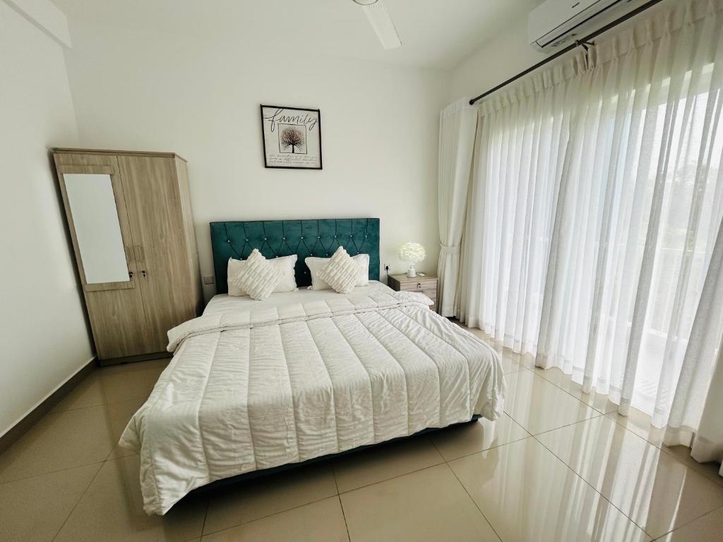 a bedroom with a large bed with white sheets at Santorini VIP in Negombo