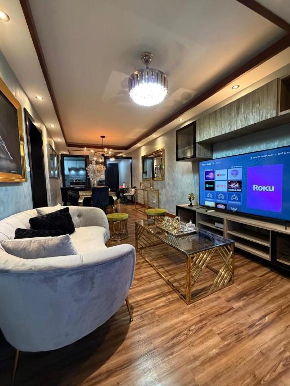 a living room with a couch and a large screen tv at Millenium Star in Mendoza