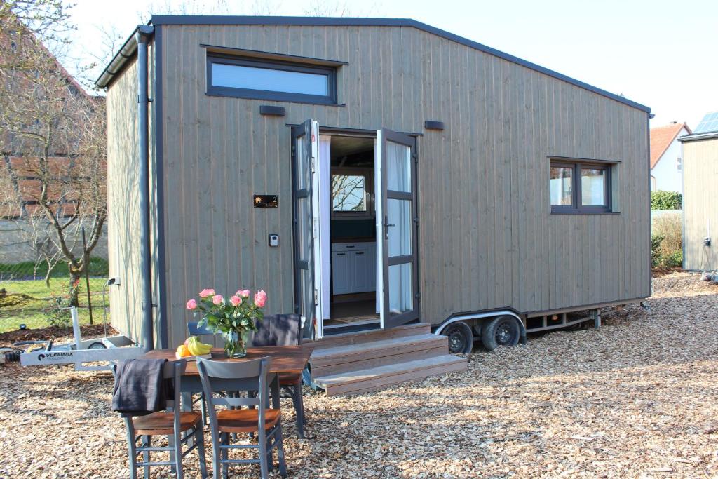 a tiny house on a trailer with a table at KE-Tiny Siedlung Haus Charlie in Oerlenbach