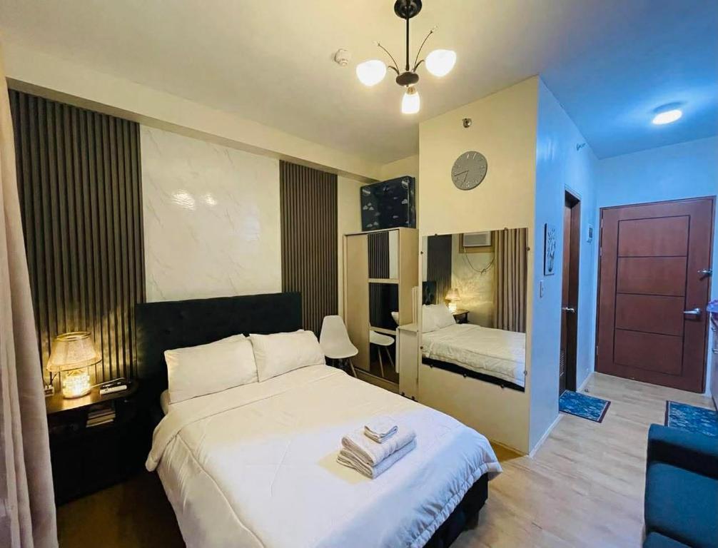 a hotel room with a bed and a bedroom with a door at Chic and Affordable Studio in Davao City