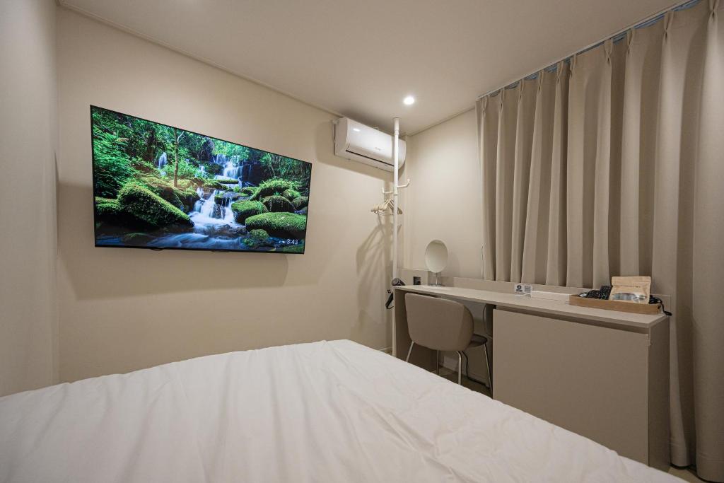 a hospital room with a tv on the wall at Parvus Sella Seongsu in Seoul