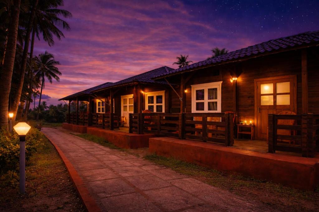 a house with a pathway in front of it at night at Lotus Feet Cottages, 100 Odd Meters from Morjim Beach in Morjim