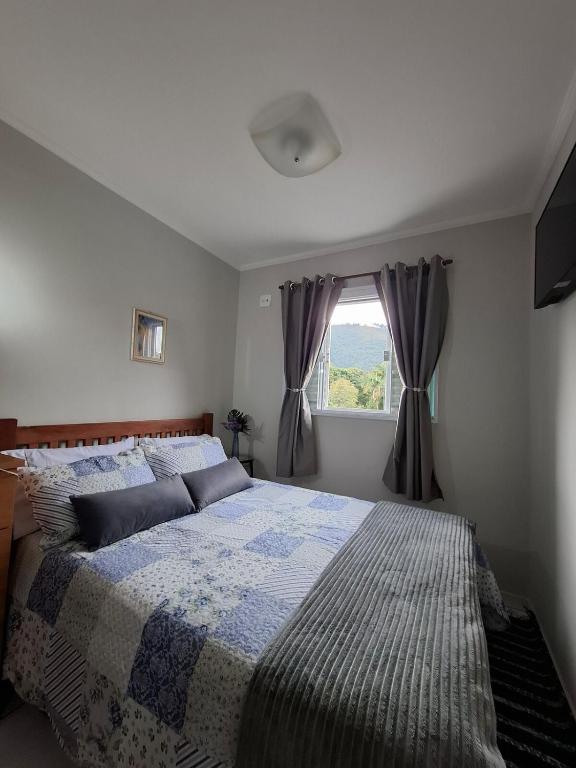 a bedroom with a large bed and a window at Espaço Van Gogh Poços de Caldas in Poços de Caldas
